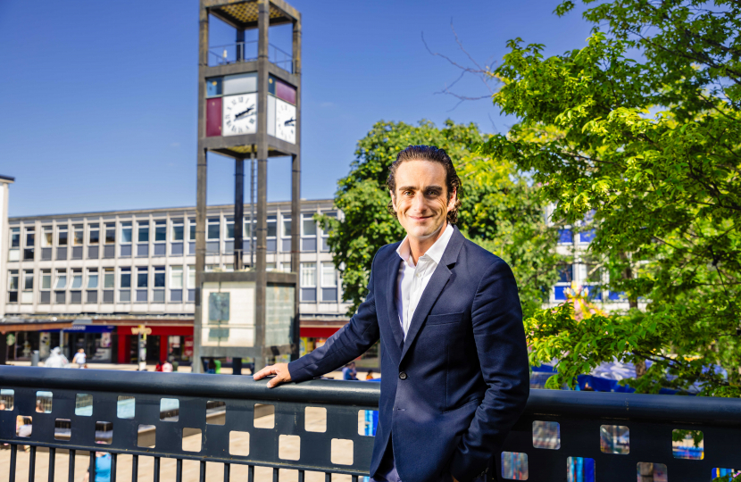 Alex Clarkson stood in Stevenage Town Centre with the town square, clock tower and tree in the background