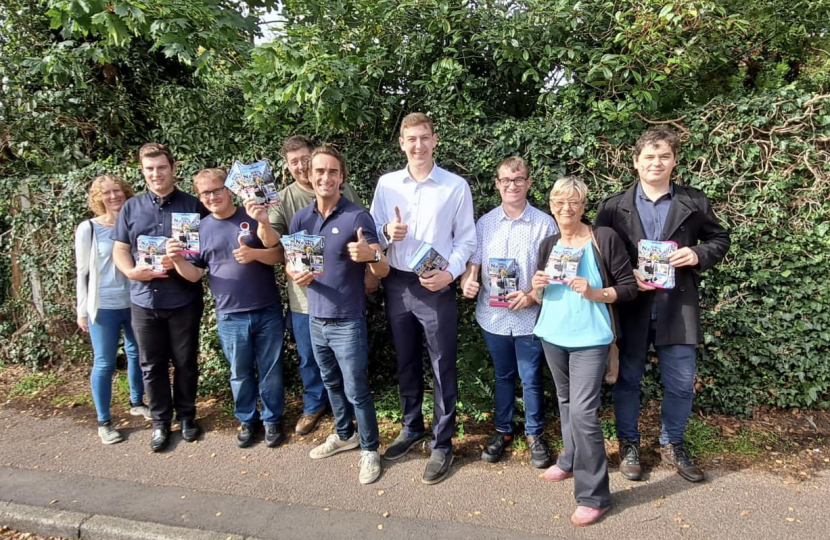 Alex Clarkson with a team of Conservative activists in Codicote. Behind them are trees and shrubs.