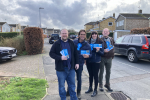 Alex Clarkson out campaigning with the Bandley Hill & Poplars Conservative team. In the background are houses, a road and a few parked cars.