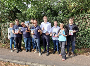 Alex Clarkson with a team of Conservative activists in Codicote. Behind them are trees and shrubs.