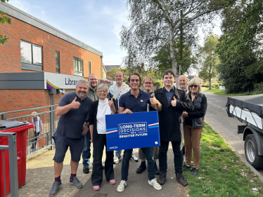 Alex Clarkson with a team of Conservative activists. In the background is Knebworth library and some trees.